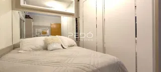 Quarto com cama e armários brancos em um imóvel.