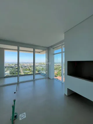 Sala de estar com grandes janelas que proporcionam uma vista panorâmica da paisagem urbana.