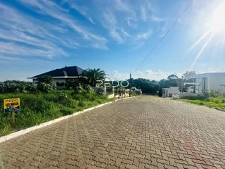 Vista da fachada de uma residência em Lajeado, Brasil, com área pavimentada na frente.