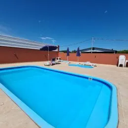 Foto de uma piscina externa azul em uma propriedade.