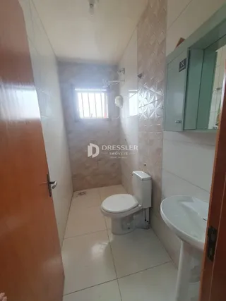 Foto de um banheiro com piso de cerâmica e azulejos nas paredes.