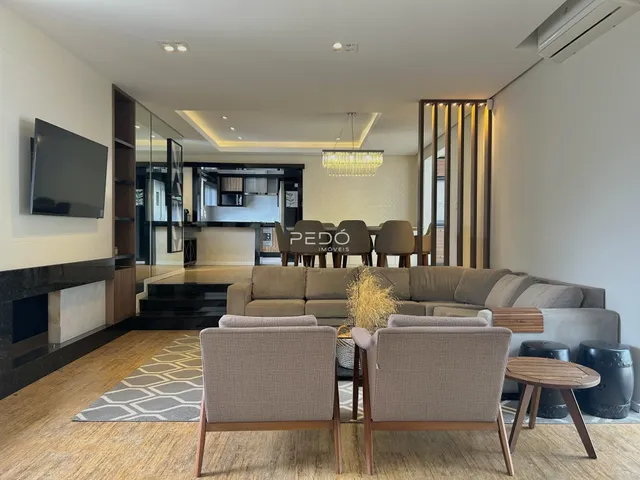 Sala de estar moderna com sofá e piso de madeira em um apartamento.