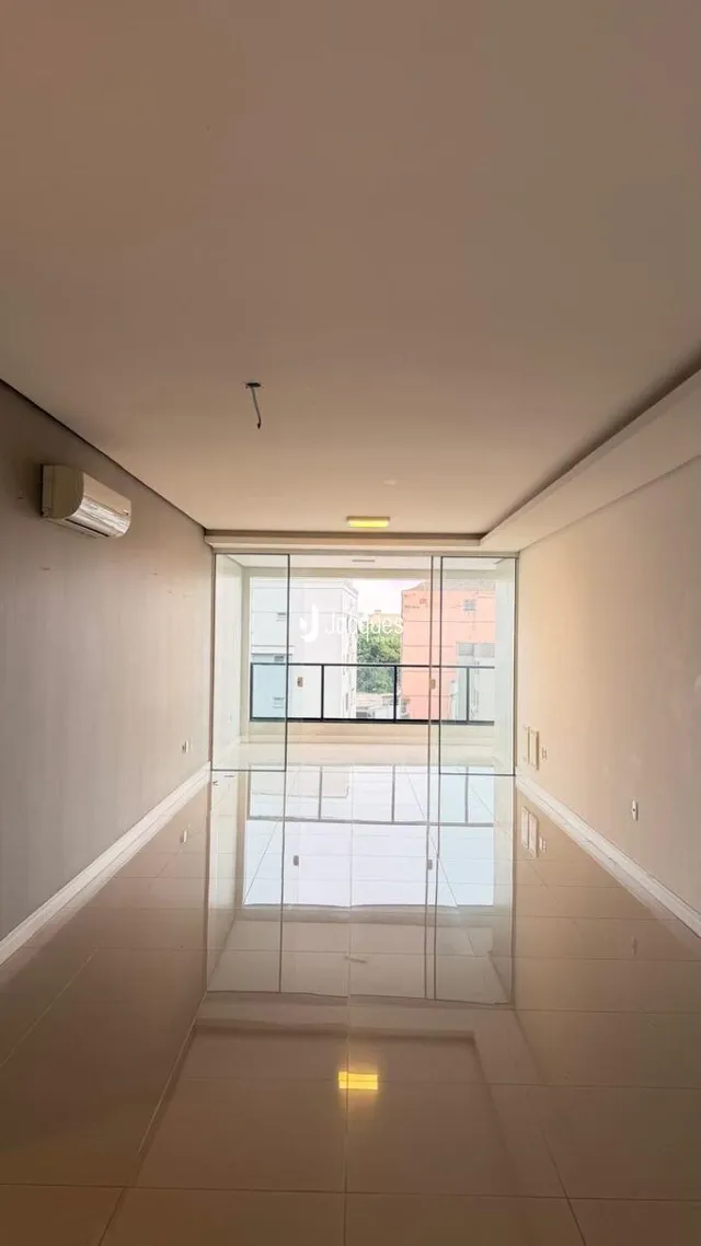 Corredor interno de um imóvel em Lajeado, Brasil, com piso de cerâmica claro.