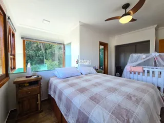 Quarto com cama e janela de madeira.