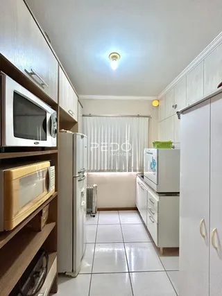 Corredor interno com armários brancos e piso cerâmico.
