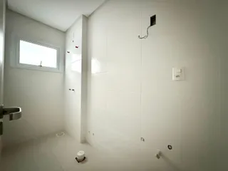 Foto de um banheiro interno com paredes brancas e piso claro.