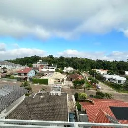 Vista aérea de uma área residencial em Lajeado, mostrando telhados e vegetação.