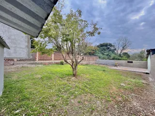 Vista externa de um terreno com gramado e muro de tijolos em Lajeado.