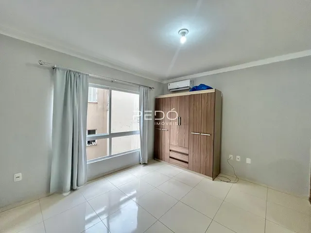 Sala de estar com piso de cerâmica e armário em madeira.