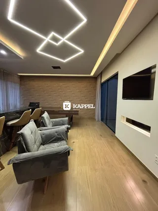 Uma sala de estar com sofá e piso de madeira clara.