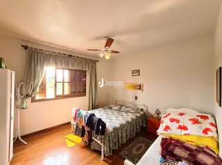 Quarto com piso de madeira e janela.