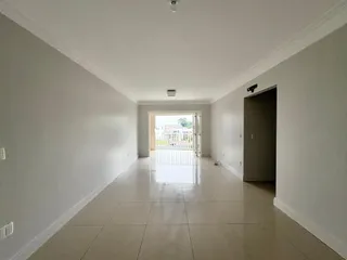 Corredor interno de uma residência com piso de cerâmica claro.