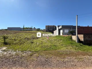 Vista externa de uma propriedade com terreno aberto e vegetação rasteira.