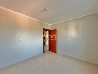 Ambiente interno de uma sala com piso de cerâmica e paredes brancas.