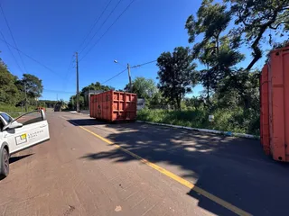 Vista externa de uma rua com vegetação ao fundo.
