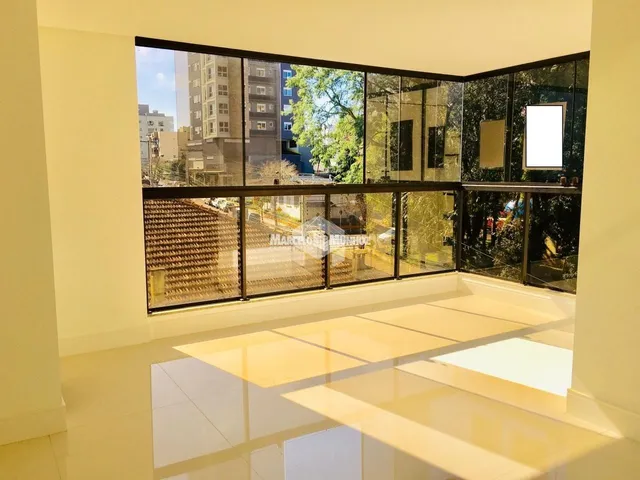 Vista de um ambiente interno com grandes janelas que dão para uma área externa.