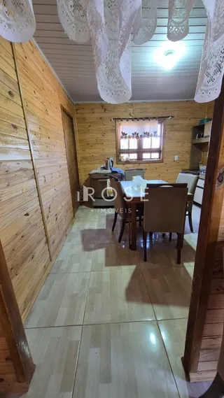 Sala de estar com paredes de madeira e piso de madeira.