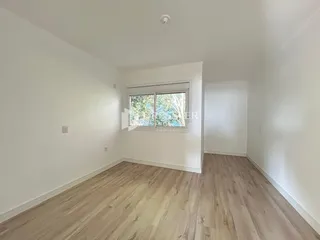 Ambiente interno com piso de madeira clara e paredes brancas.