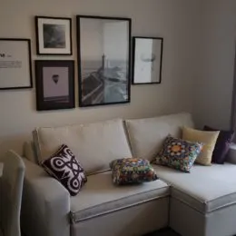 Sala de estar com sofá e quadros na parede.