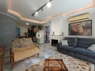 Sala de estar com sofá cinza e decoração rústica em Lajeado.