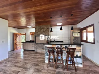 Cozinha moderna com ilha e piso de cerâmica em ambiente amplo.