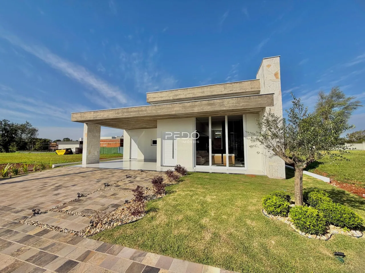 Fachada moderna de uma casa em Lajeado, Brasil, com área externa pavimentada.