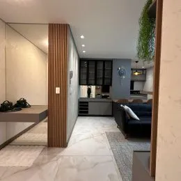 Hall de entrada com piso de mármore claro e paredes brancas.
