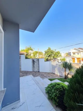 Vista externa de uma parede branca e área pavimentada em Lajeado.