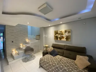 Sala de estar moderna com sofá e parede de pedra na residência.