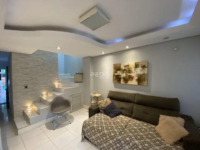 Sala de estar moderna com sofá e parede de pedra na residência.