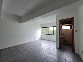 Vista interna de um ambiente com piso de cerâmica e paredes brancas.