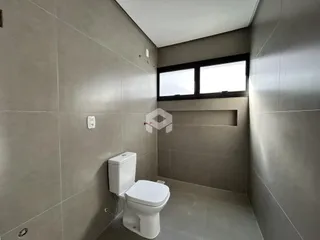 Foto de um banheiro interno com piso de cerâmica e janela.