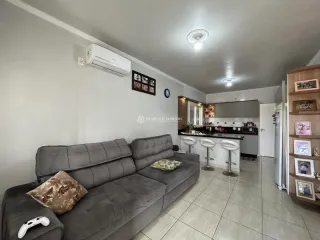Sala de estar com sofá cinza e ar condicionado instalado.