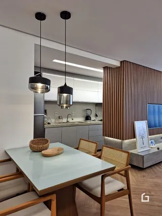 Vista de uma sala de jantar moderna com iluminação pendente.