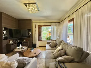 Sala de estar com sofá e televisão em um apartamento no Brasil.
