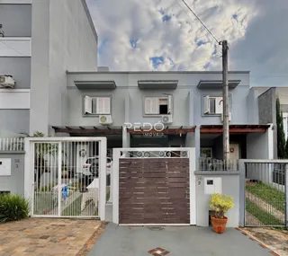 Fachada de uma residência em Lajeado, Brasil, com portão de madeira.