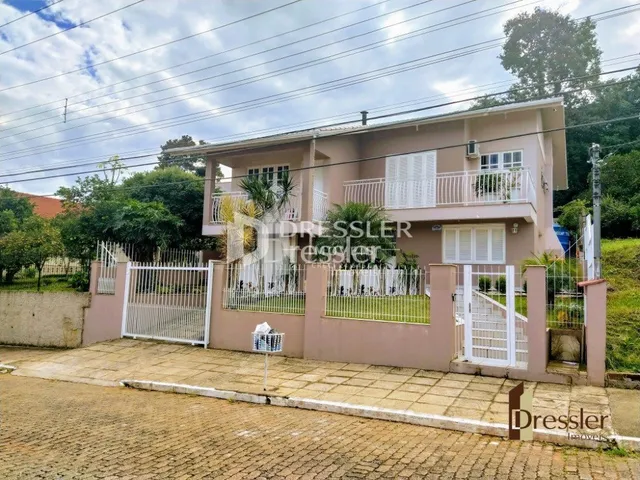 Fachada de uma residência em Lajeado, Brasil, com cerca e portão de ferro.