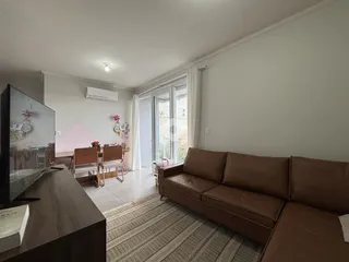 Sala de estar com sofá marrom e janela na área interna.