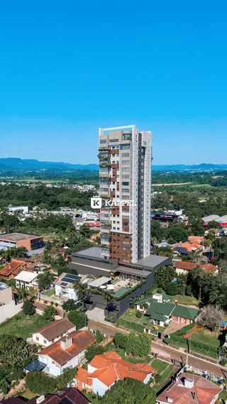 Vista aérea de um edifício alto em Lajeado, Brasil, com paisagem verde ao redor.