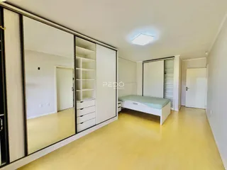 Quarto com armários embutidos e piso de madeira clara.