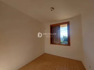 Vista interna de um cômodo com paredes brancas e piso de cerâmica.