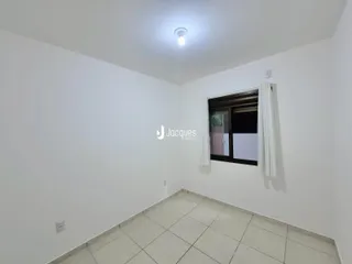 Foto de um cômodo interno com paredes brancas e piso de cerâmica.