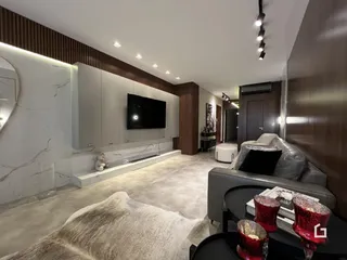 Sala de estar moderna com sofá e decoração clara.