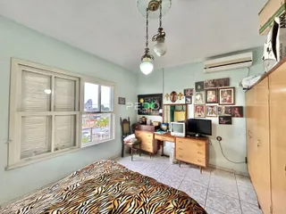 Quarto com cama e janela em uma residência no Brasil.