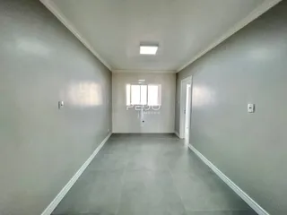 Corredor interno de uma residência com paredes cinzas e piso claro.
