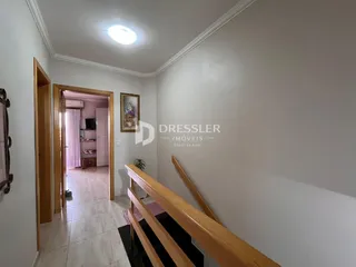 Hall de entrada com portas de madeira e escadaria visível na propriedade.