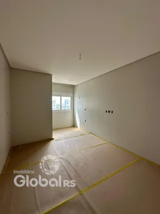 A foto mostra um ambiente interno vazio com paredes brancas e piso de carpete.