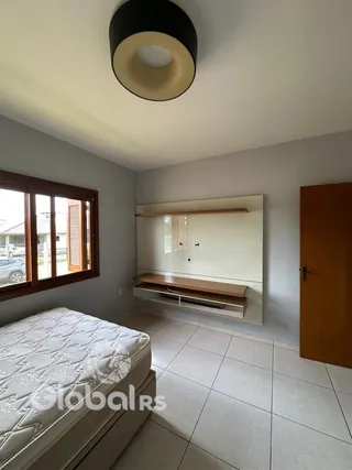 Quarto com janela de madeira e piso de cerâmica.