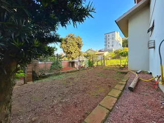 Quintal com terra e cerca de madeira de uma residência em Lajeado.