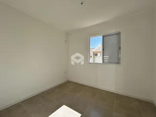 Vista interna de um cômodo com paredes brancas e piso de cerâmica.